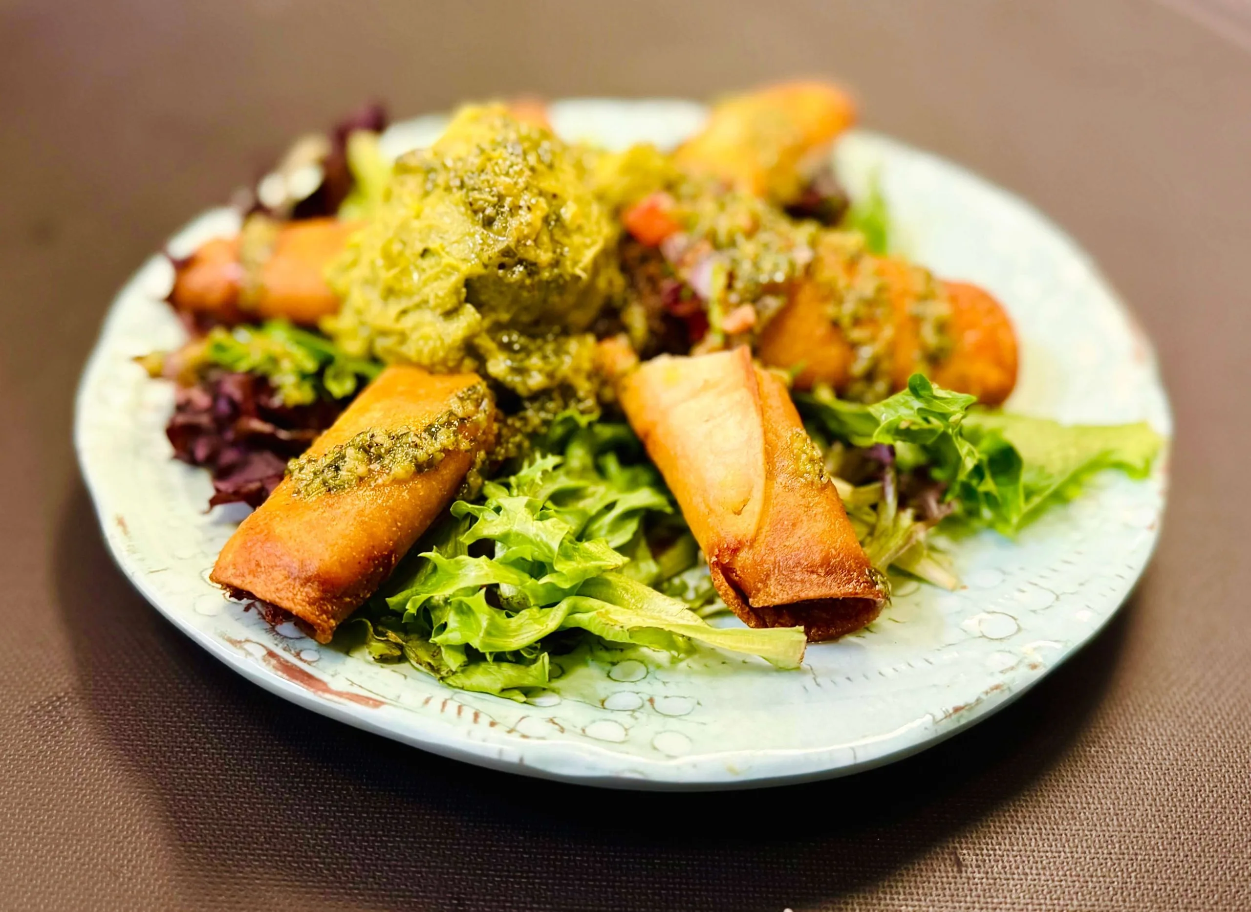 Golden crispy rolled halal wraps on garden greens with herb sauce at DJ Donair & Poutine on Ellerslie Rd SW, Edmonton