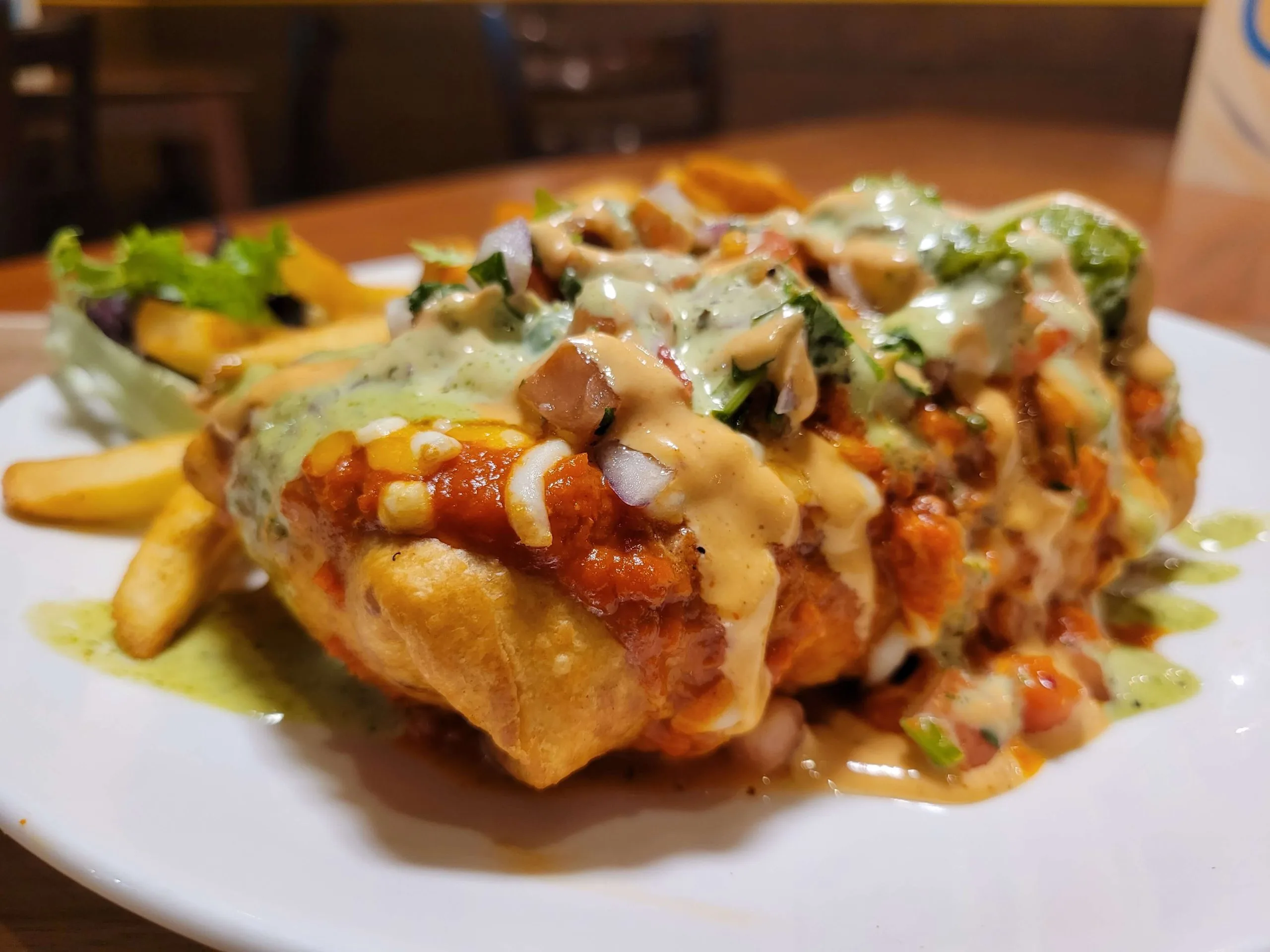 Crispy loaded fries with creamy garlic sauce and hot sauce, poutine style, at DJ Donair & Poutine in Ellerslie, Edmonton