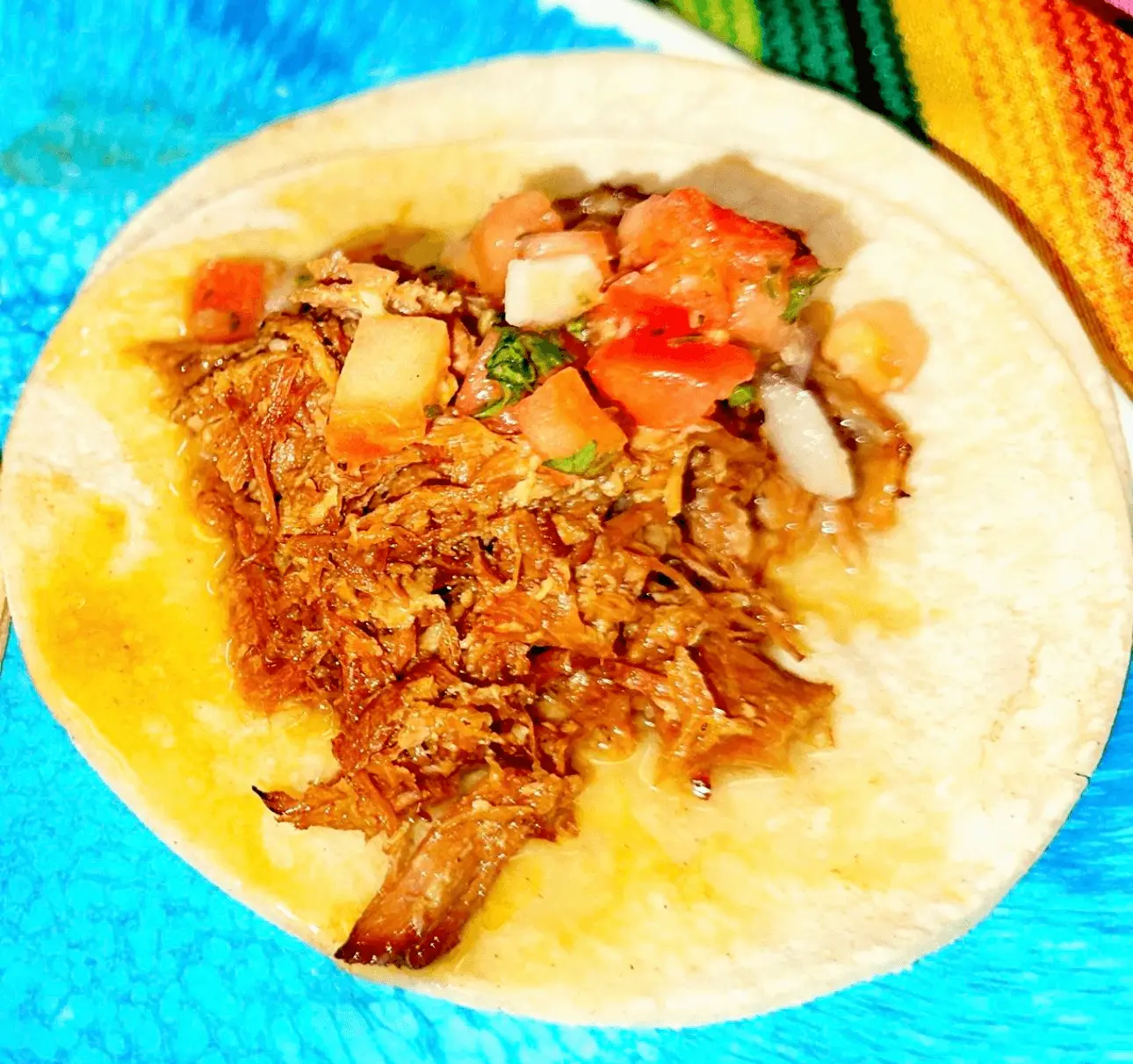 Soft flatbread piled with slow-cooked shredded halal beef, diced tomato and onion at DJ Donair & Poutine in Ellerslie, Edmonton