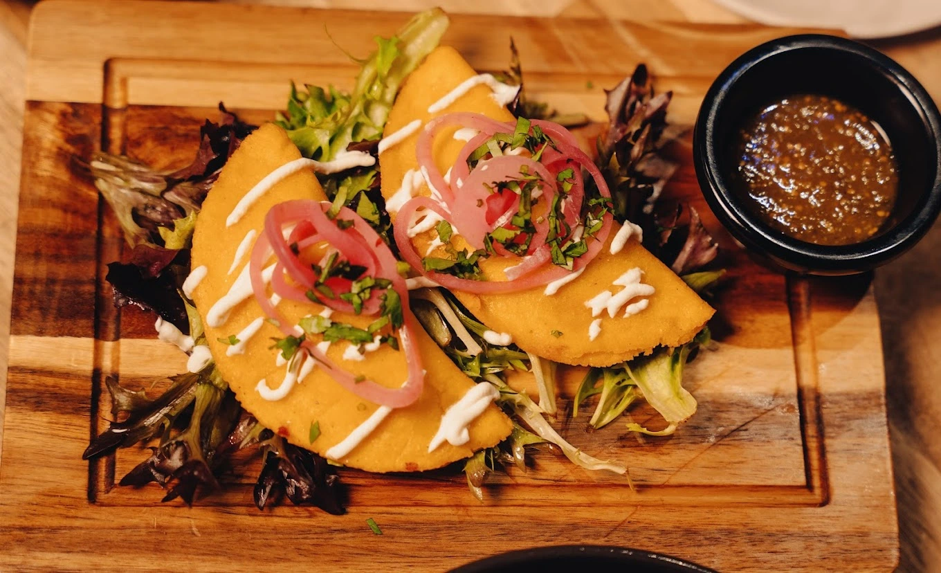 Golden stuffed halal pockets drizzled with garlic sauce and pickled onion at DJ Donair & Poutine, south Edmonton